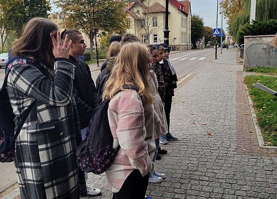 Uczniowie wykonują zadania podczas gry terenowej.