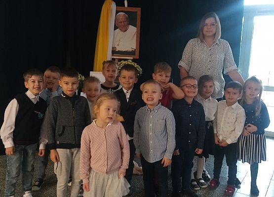 Nauczycielka z dziećmi przy portrecie Jana Pawła II