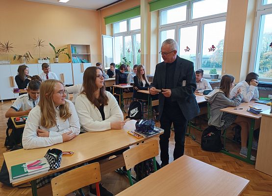 Ksiądz wręcza uczniom obrazek Jana Pawła II