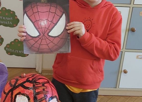 Chłopiec prezentuje pomalowaną dynię