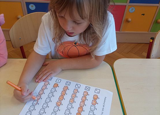 Dziewczynka uzupełnia kartę pracy