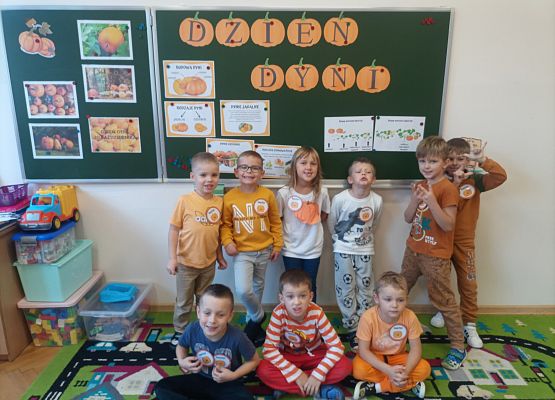 Wspólne zdjęcie przedszkolaków na tle napisu dzień dyni