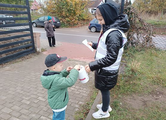 Chłopiec wrzuca darowiznę do puszki