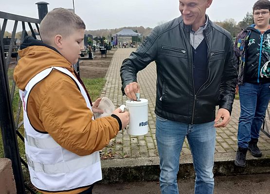 Mężczyzna wręcza darowiznę do puszki