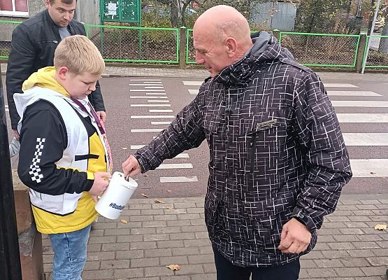 Mężczyzna wręcza darowiznę do puszki