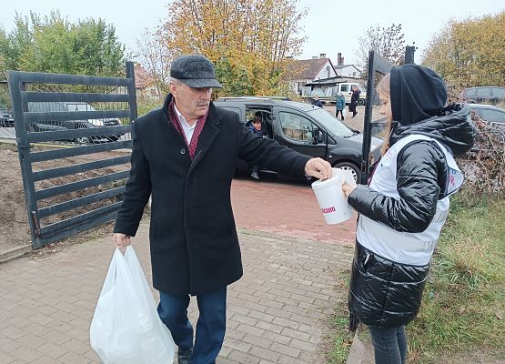 Mężczyzna wrzuca darowiznę do puszki