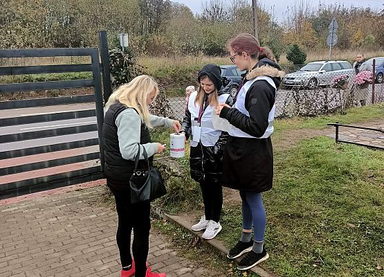 Kobieta wrzuca darowiznę do puszki