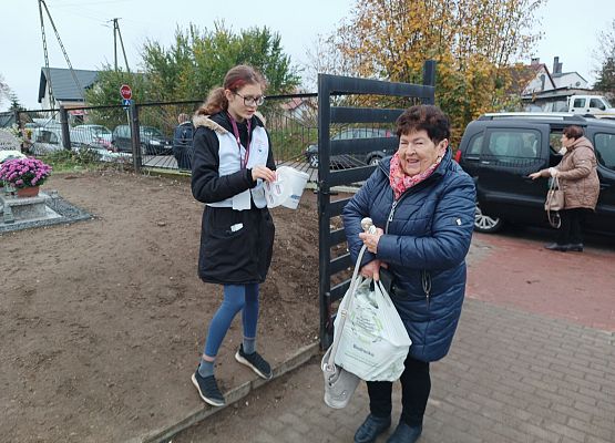 Kobieta wrzuca darowiznę do puszki