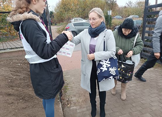 Wolontariuszka wręcza naklejkę darczyńcy