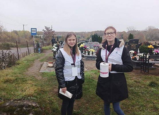 Dwie wolontariuszki stoją i trzymają puszki
