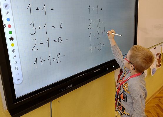 Chłopiec pracuje na monitorze interaktywnym