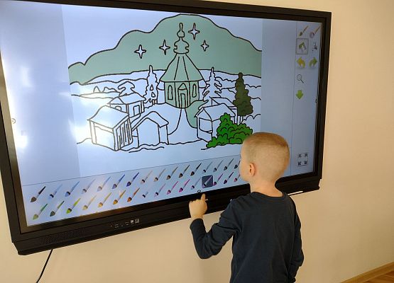 Chłopiec pracuje na monitorze interaktywnym