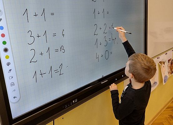 Chłopiec pracuje na monitorze interaktywnym