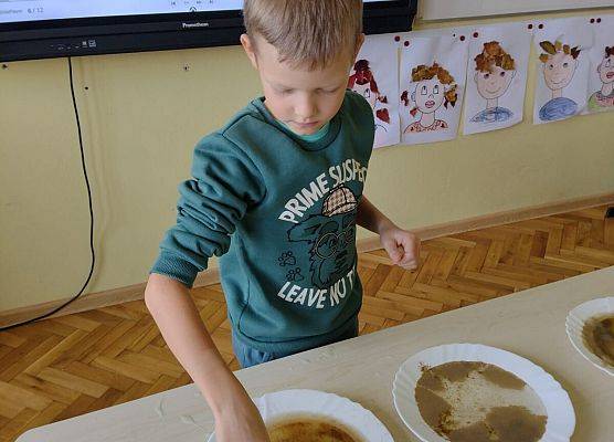 Uczeń wykonuje eksperyment z wodą, mydłem i pieprzem
