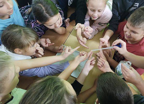 Dzieci wykonują eksperyment z wodą, mydłem i pieprzem