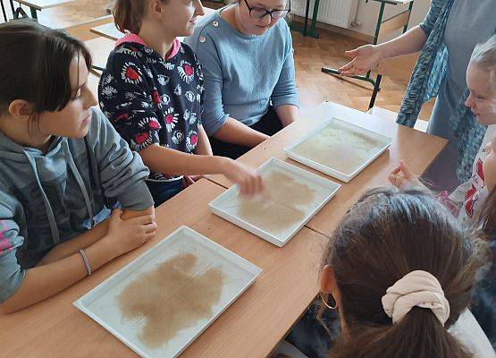 Nauczycielka przeprowadza z uczniami eksperyment