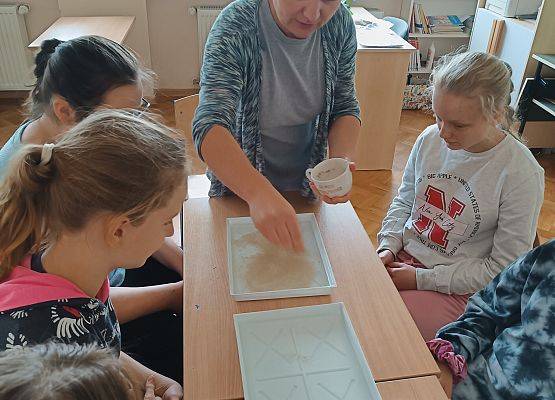 Nauczycielka przeprowadza z uczniami eksperyment