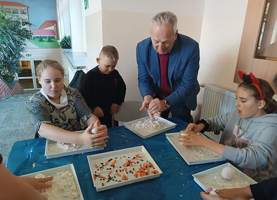 Pan dyrektor z uczniami lepi bałwana Olafa