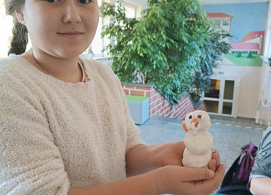 Uczennica prezentuje małego bałwanka Olafa