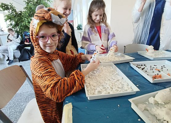 Dzieci lepią bałwanki