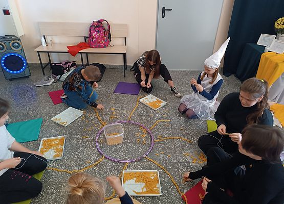 Uczniowie nawlekają makaron na sznurki