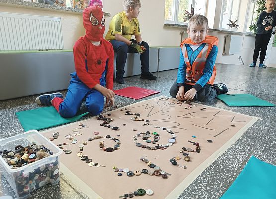 Uczniowie układają guziki