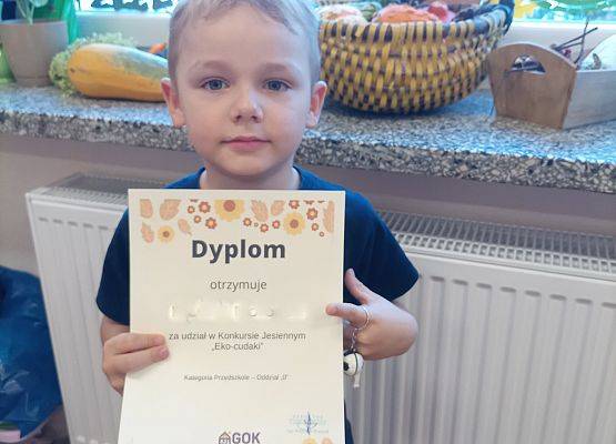 Chłopiec prezentuje swój dyplom