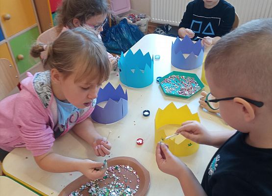 Dzieci ozdabiaj cekinami papierowe korony