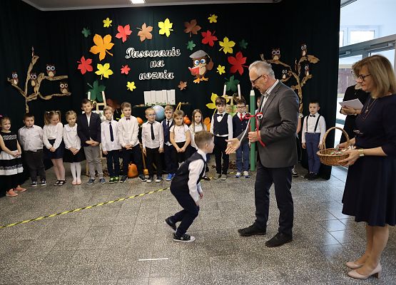 Dyrektor pasuje chłopca na ucznia