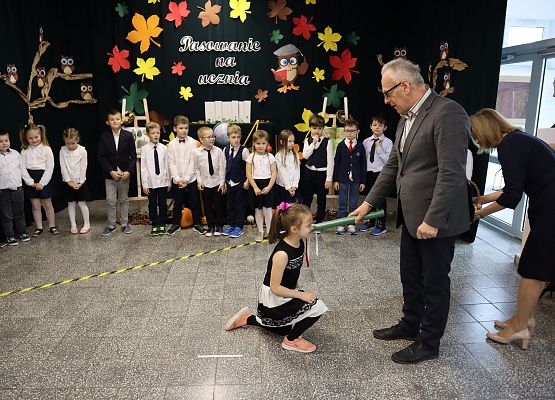 Dyrektor pasuje dziewczynkę na uczennicę