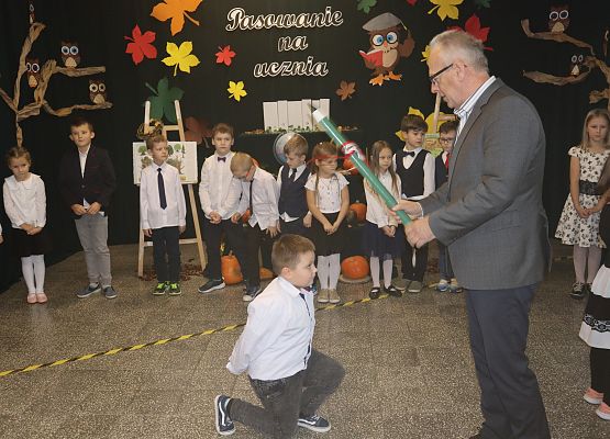 Dyrektor pasuje chłopca na ucznia