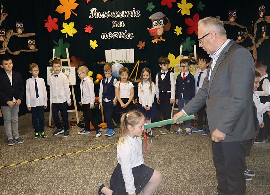 Dyrektor pasuje dziewczynkę na uczennicę