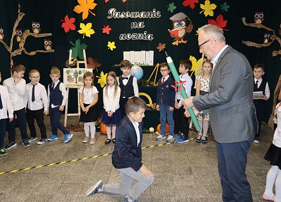 Dyrektor pasuje chłopca na ucznia