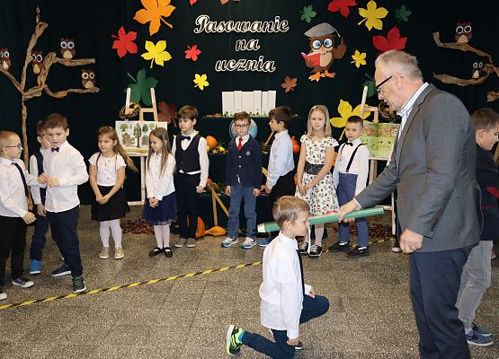 Dyrektor pasuje chłopca na ucznia