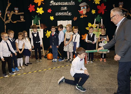 Dyrektor pasuje chłopca na ucznia