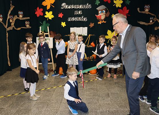 Dyrektor pasuje chłopca na ucznia