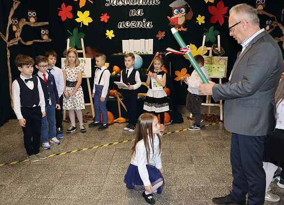 Dyrektor pasuje dziewczynkę na uczennicę