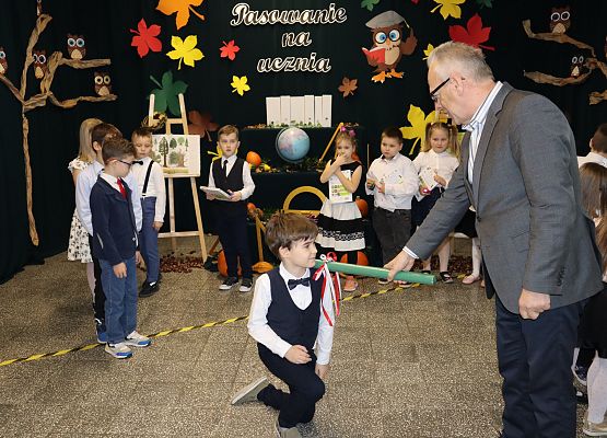 Dyrektor pasuje chłopca na ucznia