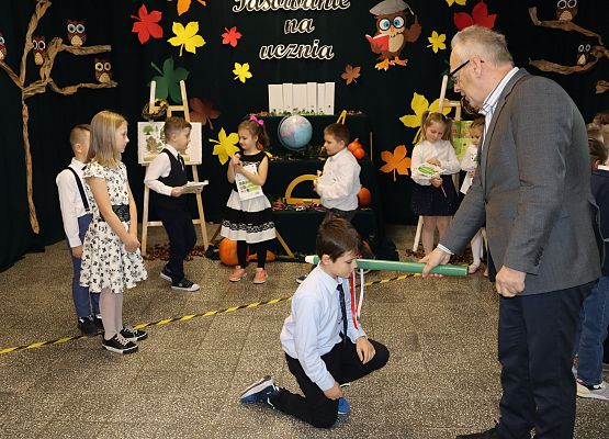 Dyrektor pasuje chłopca na ucznia