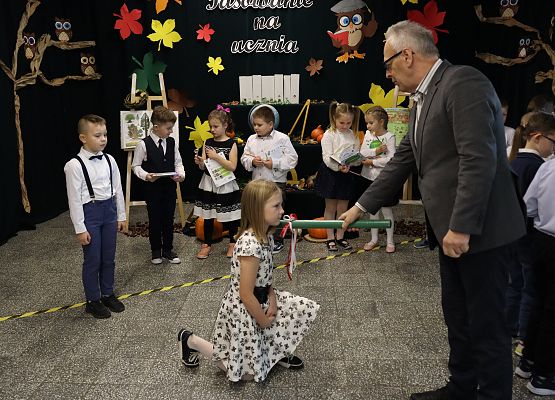 Dyrektor pasuje dziewczynkę na uczennicę