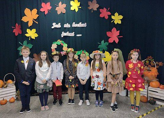 Uczniowie w jesiennych przebraniach stoją na scenie