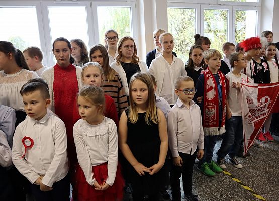 Uczniowie śpiewają hymn w szkolnym holu