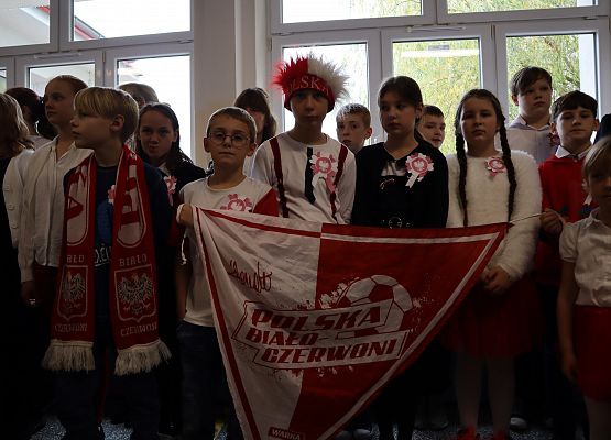 Uczniowie śpiewają hymn w szkolnym holu