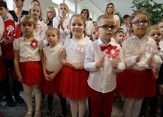 Uczniowie śpiewają hymn w szkolnym holu