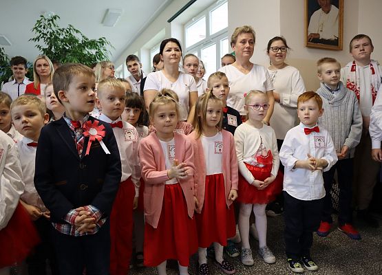 Uczniowie śpiewają hymn w szkolnym holu