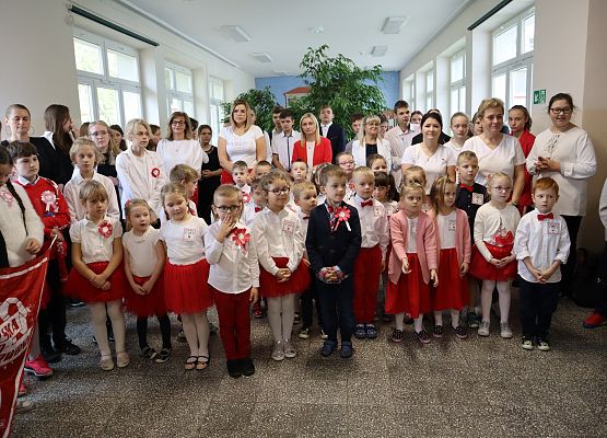 Uczniowie śpiewają hymn w szkolnym holu