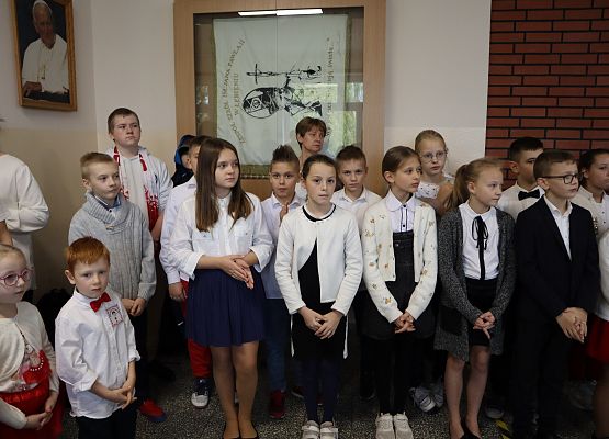 Uczniowie śpiewają hymn w szkolnym holu