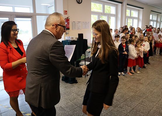 Dyrektor wręcza dyplom uczennicy