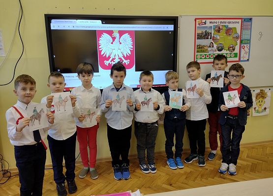 Chłopcy prezentują pokolorowane obrazki