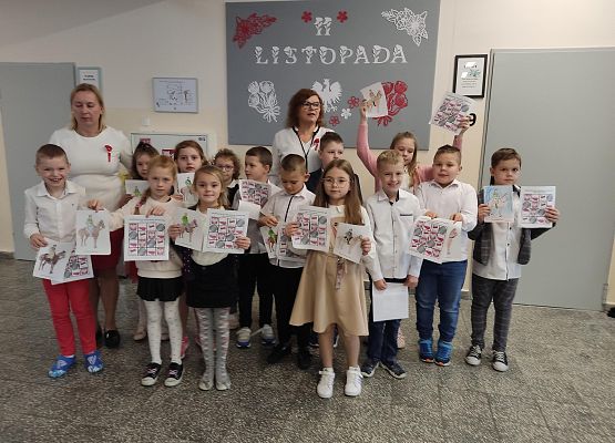 Uczniowie i nauczycielki na tle szkolnej gazetki